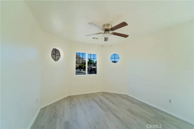 a view of a big room with wooden floor and windows