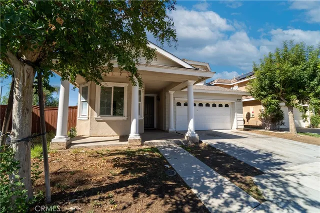 a front view of a house with a tree