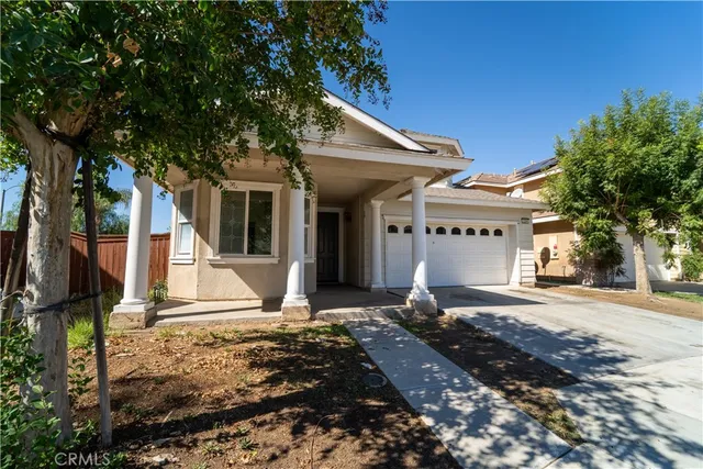 a front view of a house with a tree