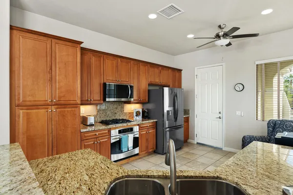 a kitchen with stainless steel appliances granite countertop a refrigerator stove and sink