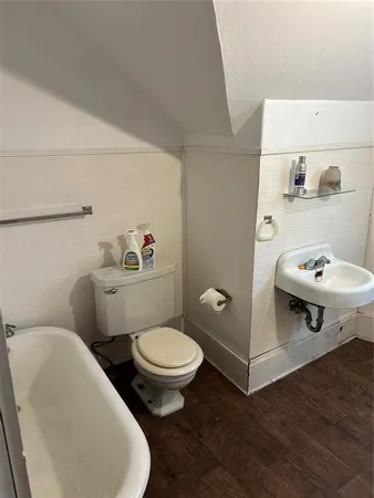 a white toilet sitting next to a bathroom sink and vanity