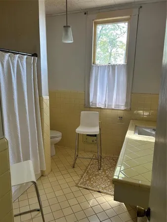 a bathroom with a toilet a sink and mirror