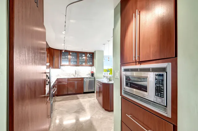a kitchen with stainless steel appliances granite countertop a sink a stove and a refrigerator