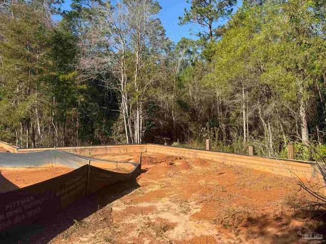 a view of a yard with wooden fence