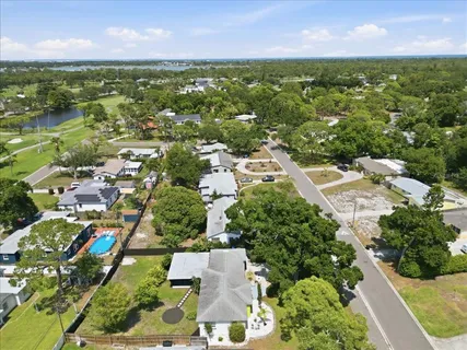 an aerial view of residential houses with outdoor space and trees