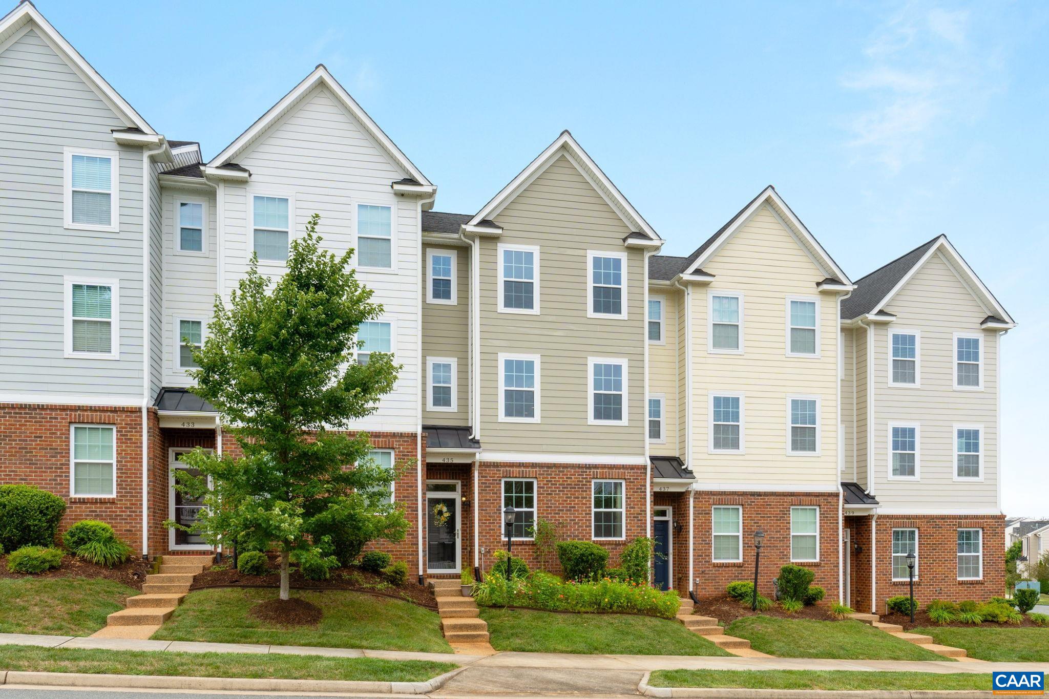 a front view of residential houses with yard and green space