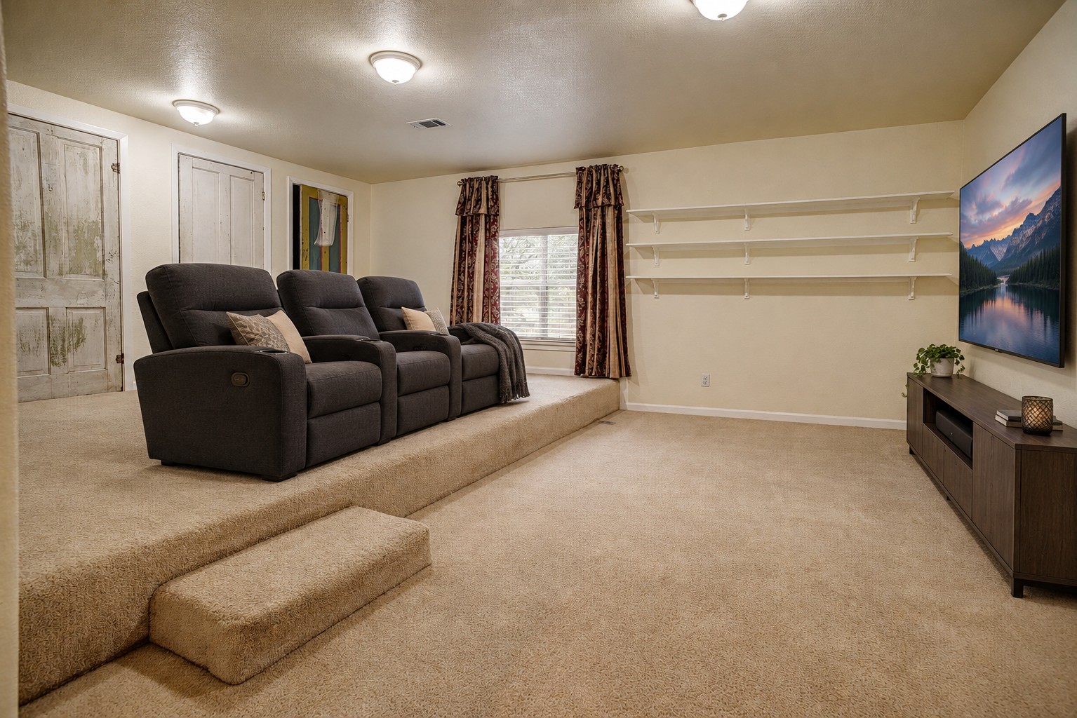 147 Spring Meadow Road Bastrop, TX 78602 - Photo 27 of 40 A spacious carpeted media room includes tiered flooring and built-in wall shelving.