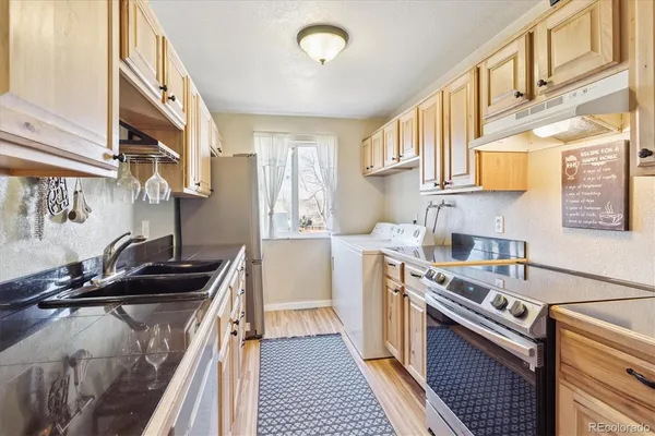 a kitchen with a sink a stove and cabinets