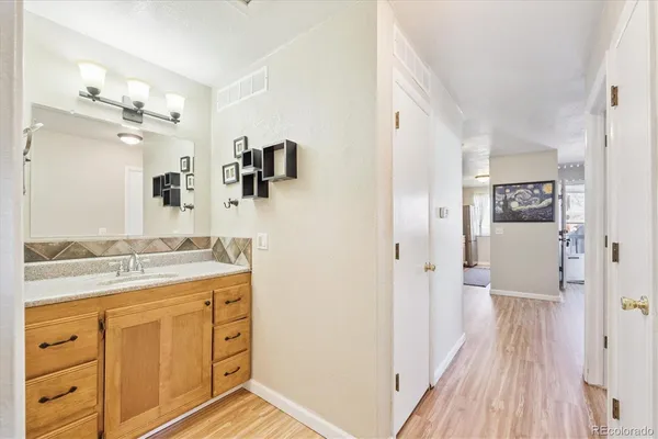 a bathroom with a granite countertop sink a mirror a vanity and a shower