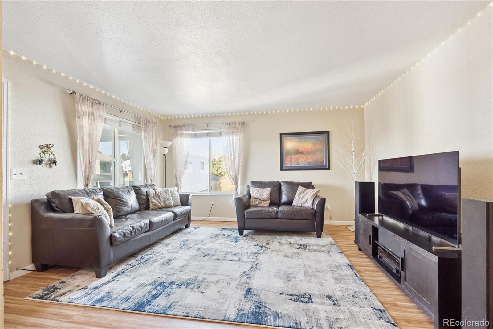 7984 Chase Circle, Unit 68 Arvada, CO 80003 - Photo 4 of 27 a living room with furniture and a flat screen tv