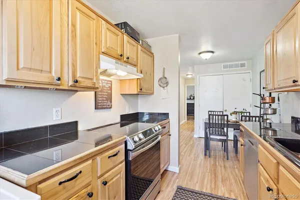 a kitchen with stainless steel appliances granite countertop a stove a sink and a refrigerator