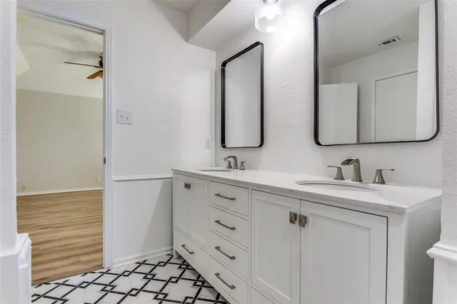 a bathroom with a double vanity sink mirror and