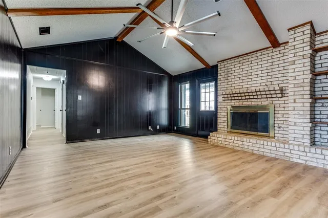 a view of an empty room with a fireplace and a window