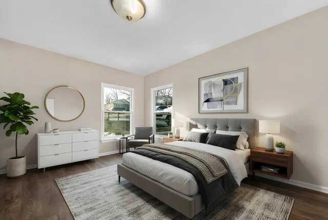 a bedroom with a large bed and wooden floor