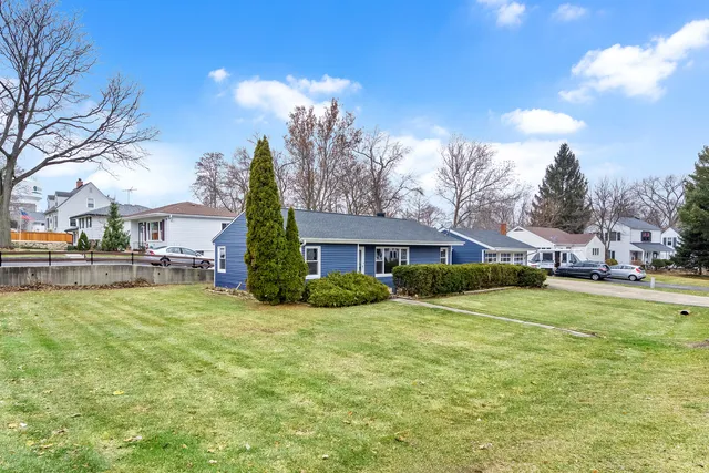 a view of a house with a big yard and large trees