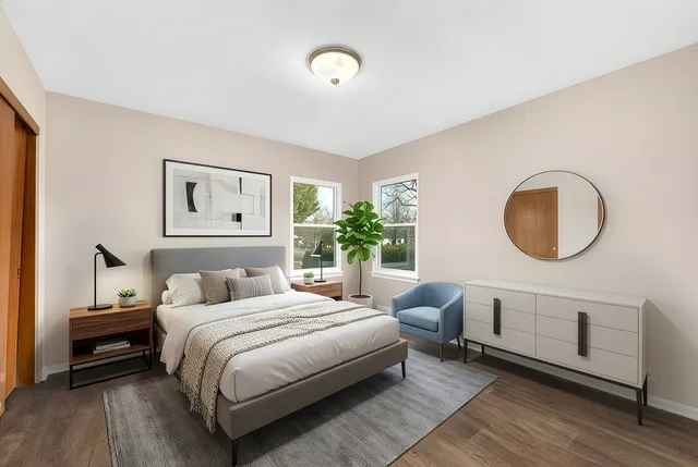 a bedroom with a bed lamp closet and large window