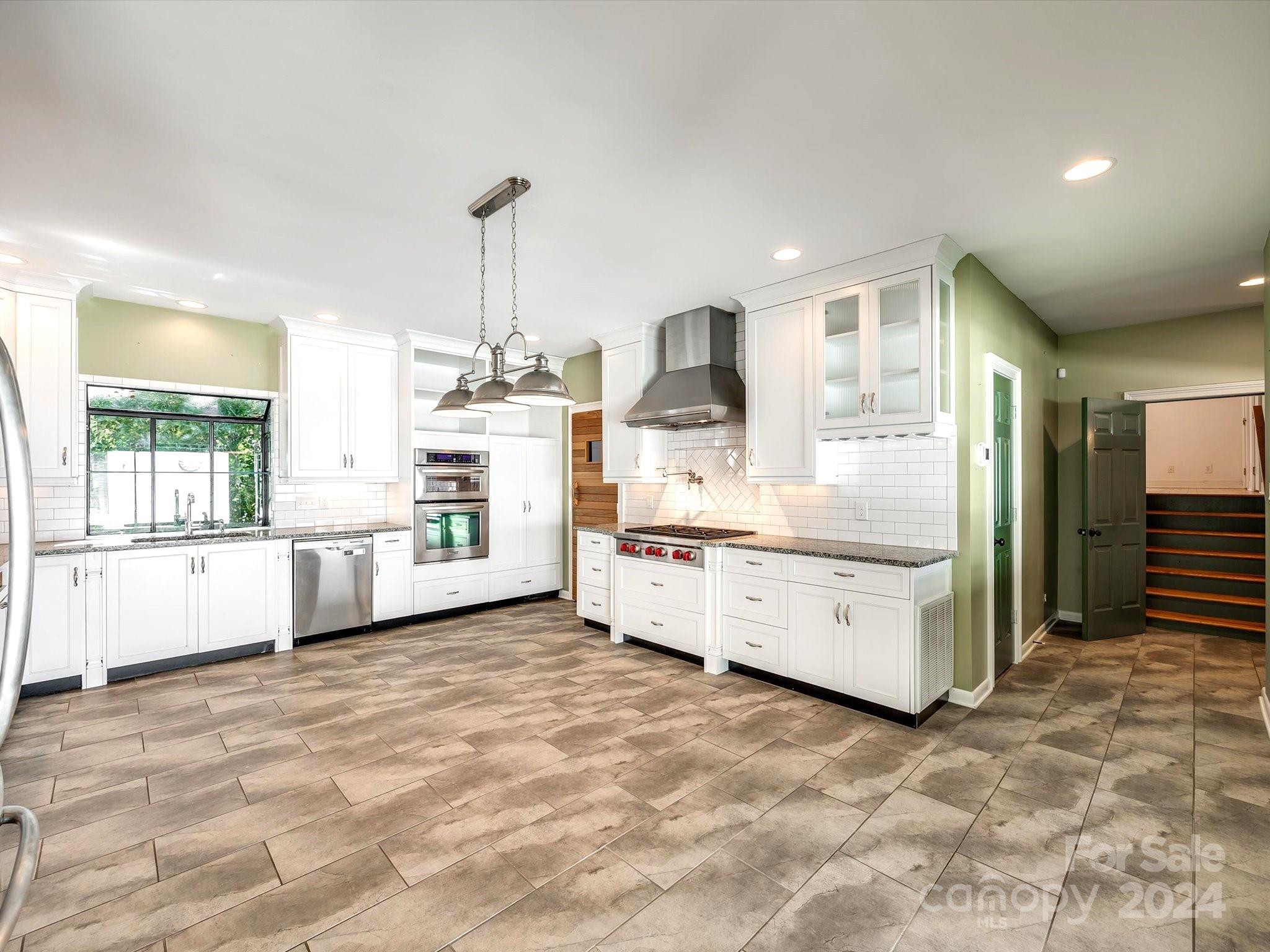 4001 Rounding Run Road Charlotte, NC 28277 - Photo 9 of 42 a large white kitchen with kitchen island a sink a stove and white cabinets