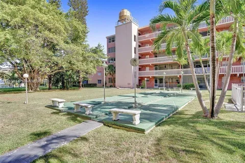 a view of a house with a yard and palm trees