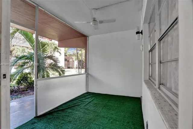 a view of an empty room with a window and hardwood floor