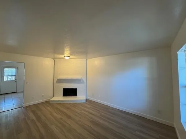 an empty room with wooden floor and fireplace