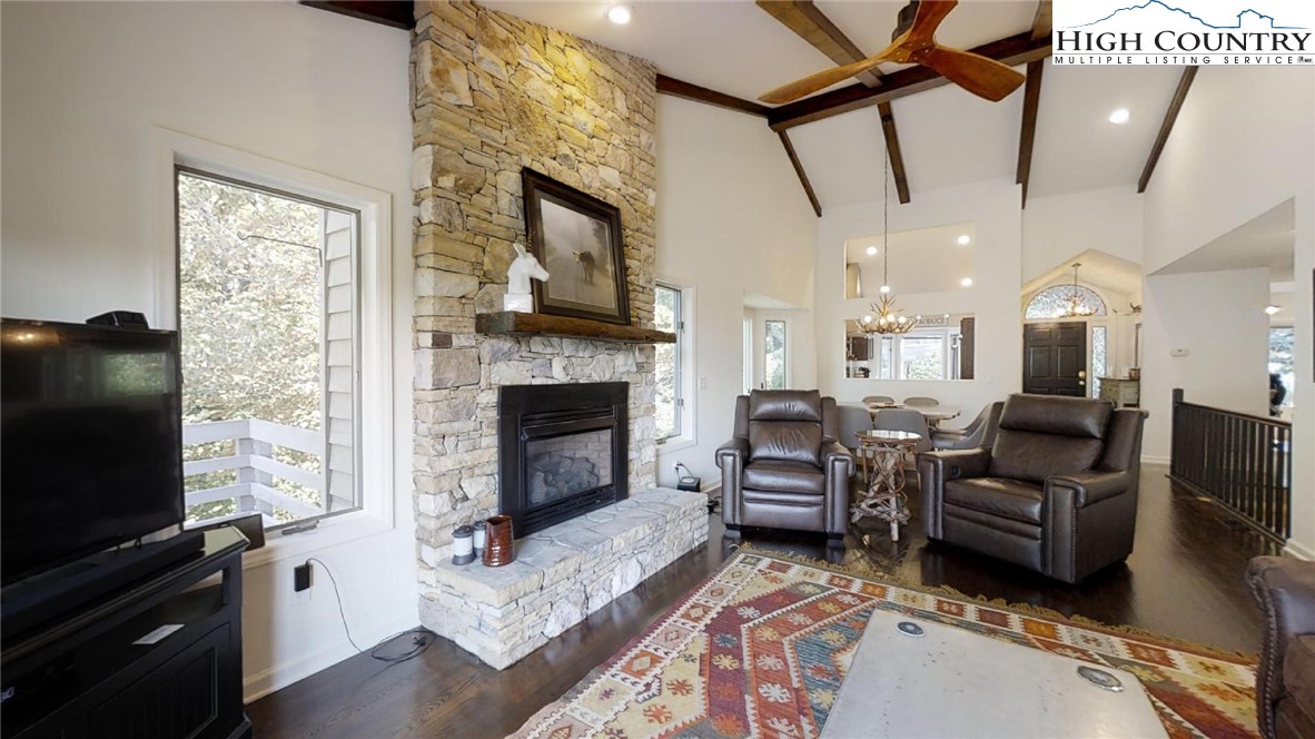 a living room with furniture a flat screen tv and a fireplace