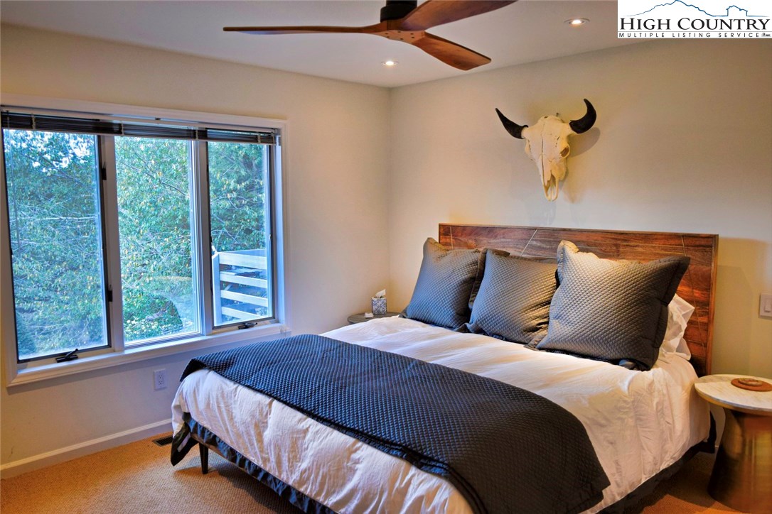 250 Ascot Lane Boone, NC 28607 - Photo 25 of 44 a bedroom with a large bed and a large window