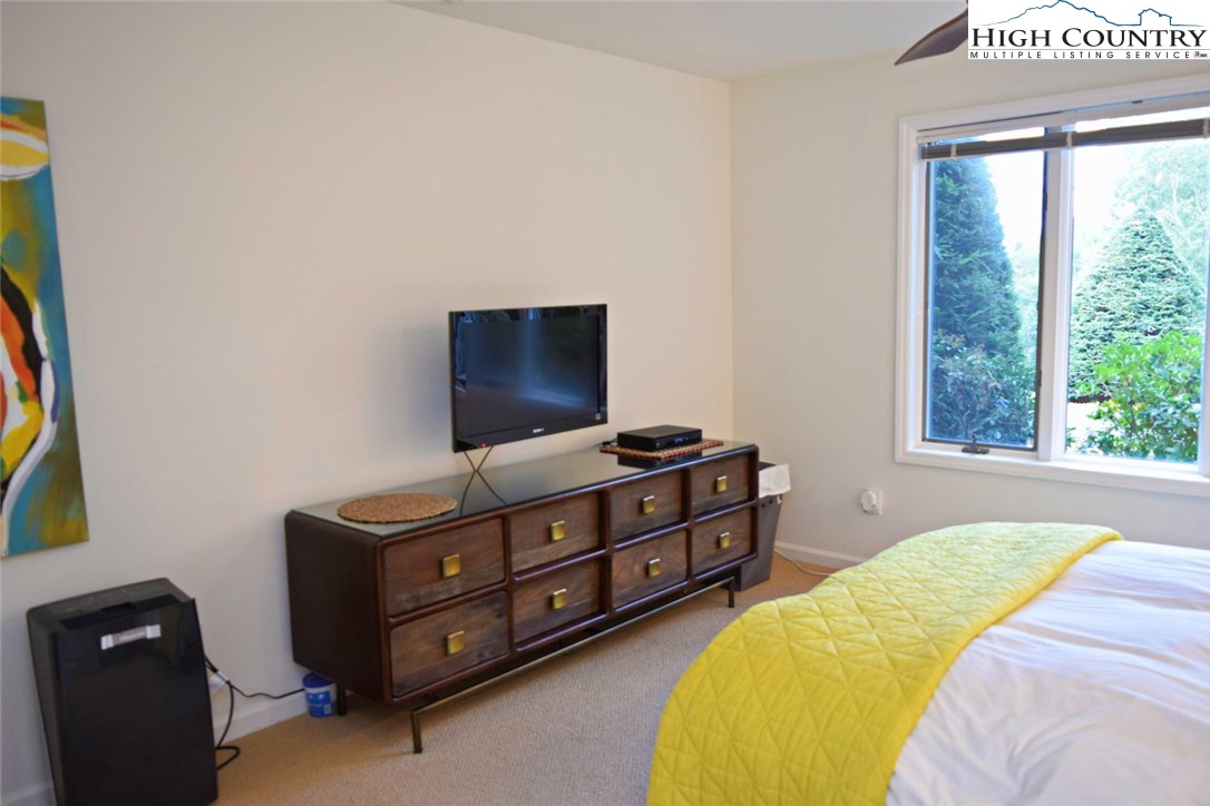 250 Ascot Lane Boone, NC 28607 - Photo 29 of 44 a bedroom with a bed and a flat tv screen on a dresser