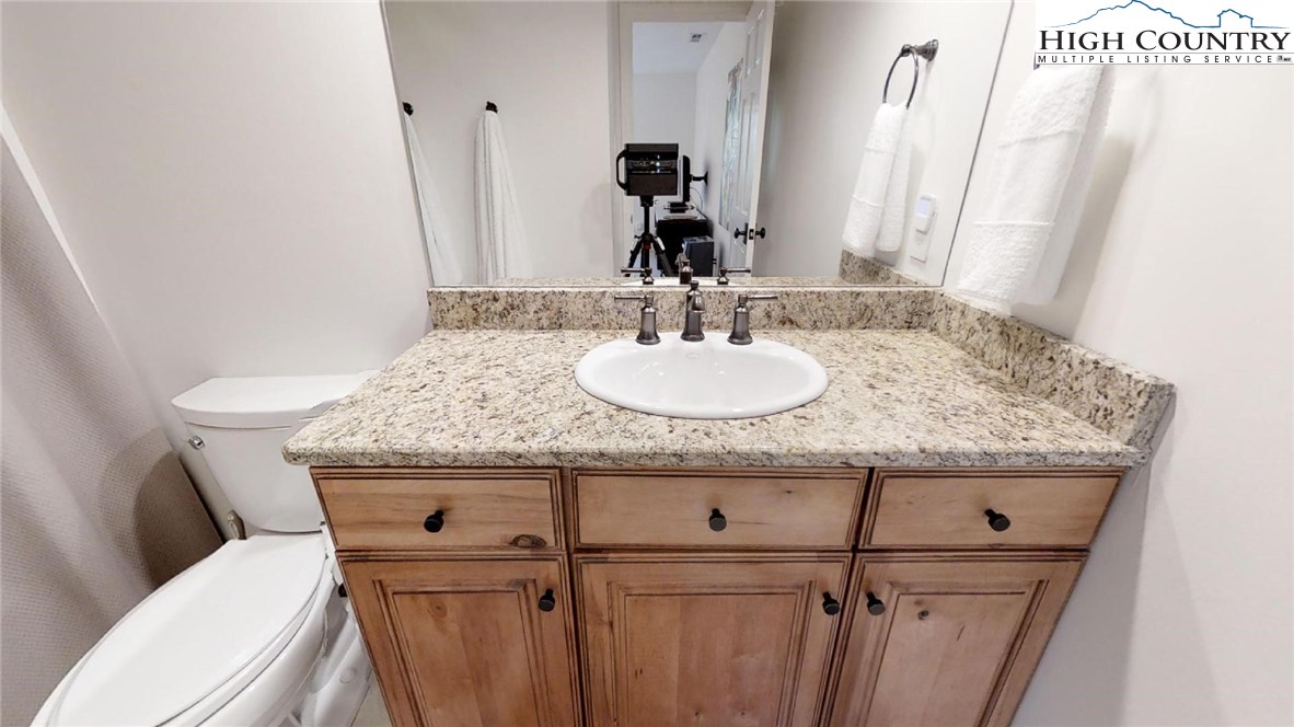 250 Ascot Lane Boone, NC 28607 - Photo 39 of 44 a bathroom with a granite countertop toilet sink and mirror