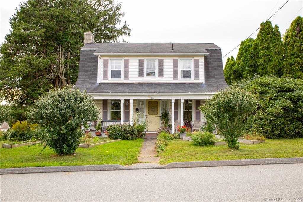 a front view of a house with a garden and plants