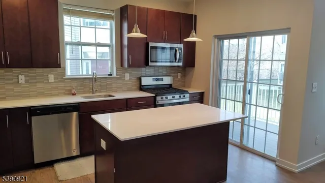 a kitchen with stainless steel appliances a sink stove and microwave