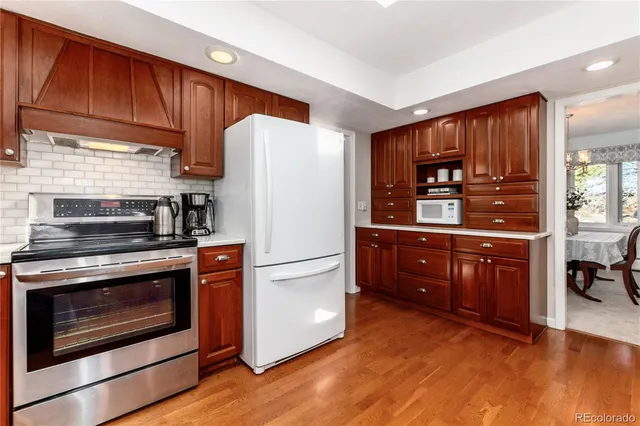 a kitchen with a refrigerator stove and wooden cabinets