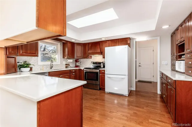 a kitchen with stainless steel appliances a refrigerator a stove a sink and a oven