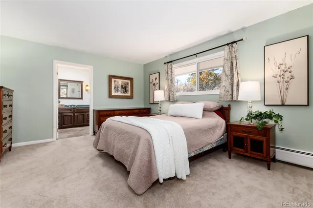 a bedroom with a bed and a painting on the wall