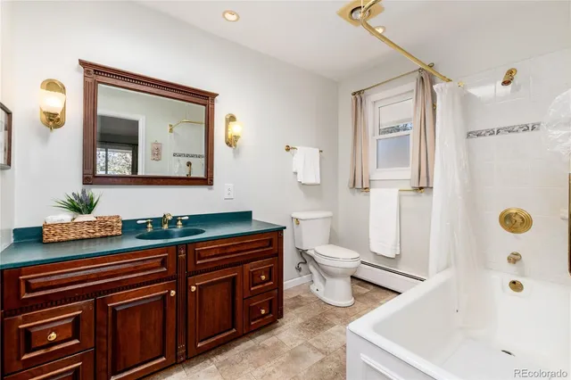 a bathroom with a sink a toilet and shower curtain