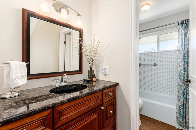 a bathroom with a granite countertop sink and a mirror