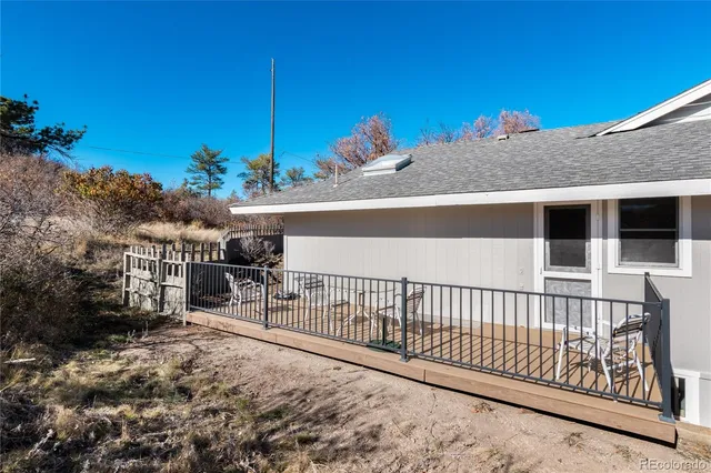 a view of a house with a small yard and wooden fence
