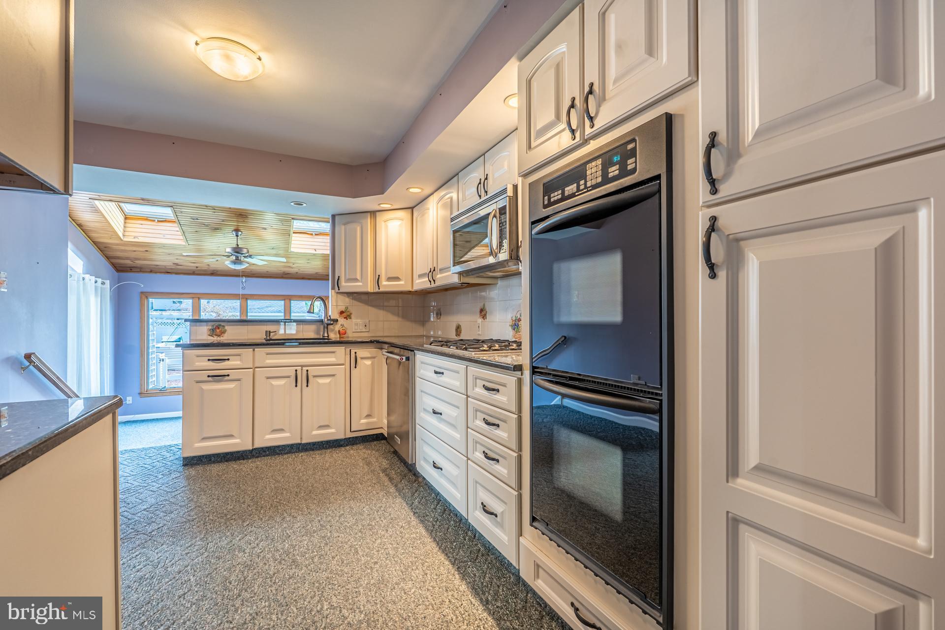 159 Forrest Avenue Southampton, PA 18966 - Photo 7 of 48 a kitchen with stainless steel appliances granite countertop white cabinets and window