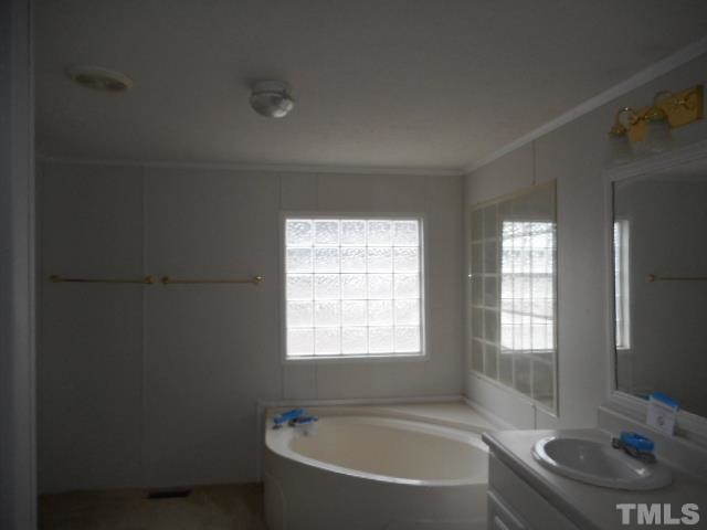 8124 Wiggins Mill Road Lucama, NC 27851 - Photo 11 of 12 a bathroom with a bathtub and a sink