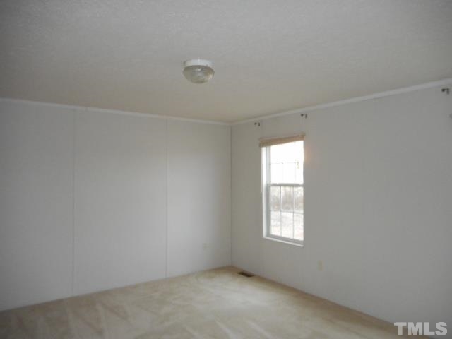 8124 Wiggins Mill Road Lucama, NC 27851 - Photo 5 of 12 an empty room with a window