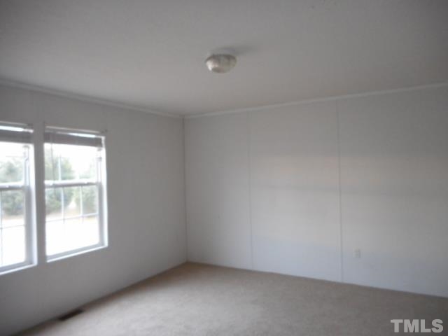 8124 Wiggins Mill Road Lucama, NC 27851 - Photo 9 of 12 an empty room with a window