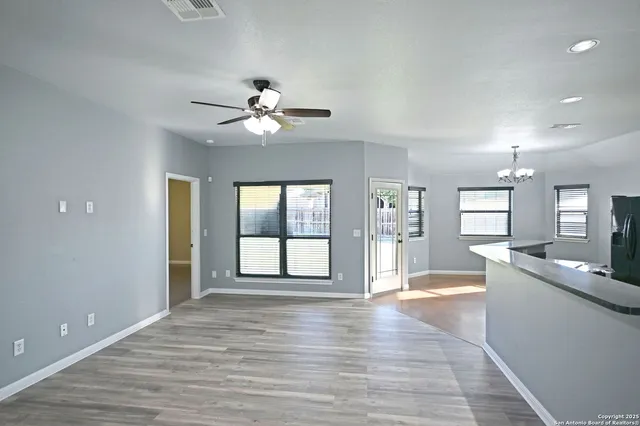 a view of an empty room with window and wooden floor