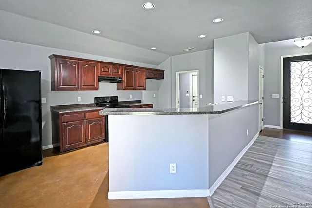 a kitchen with stainless steel appliances granite countertop a stove a sink and a refrigerator