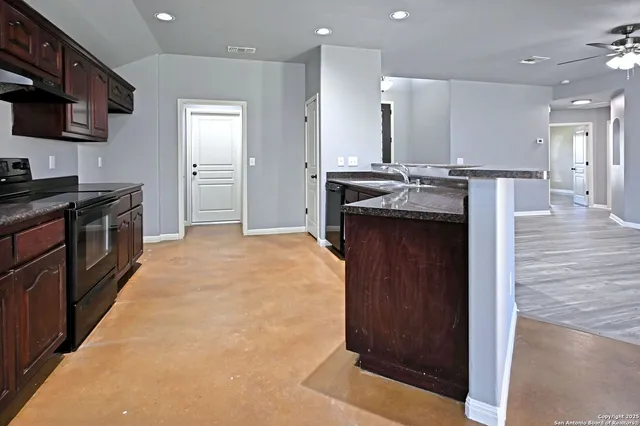 a kitchen with stainless steel appliances granite countertop a stove a sink and a refrigerator