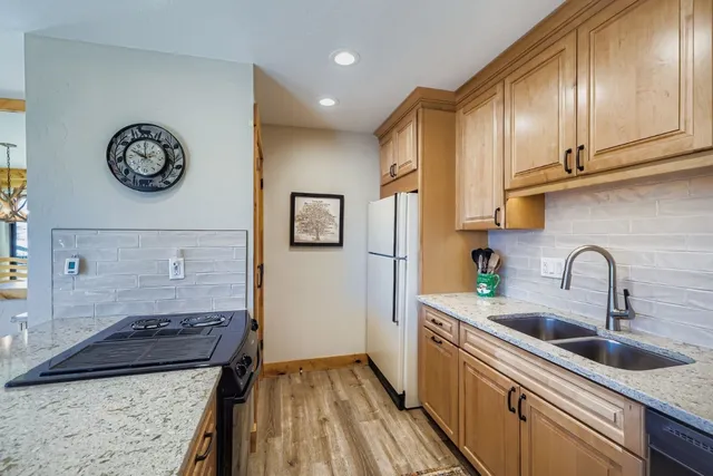 a kitchen with stainless steel appliances granite countertop a refrigerator and a stove top oven