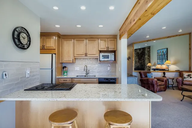 a kitchen with kitchen island granite countertop a table and chairs in it