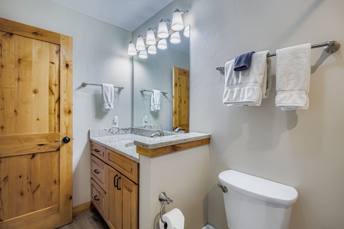160 La Bonte Street, Unit 306 Dillon, CO 80435 - Photo 21 of 47 a bathroom with a granite countertop sink toilet and mirror