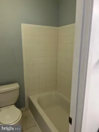 a white toilet sitting next to a bath tub