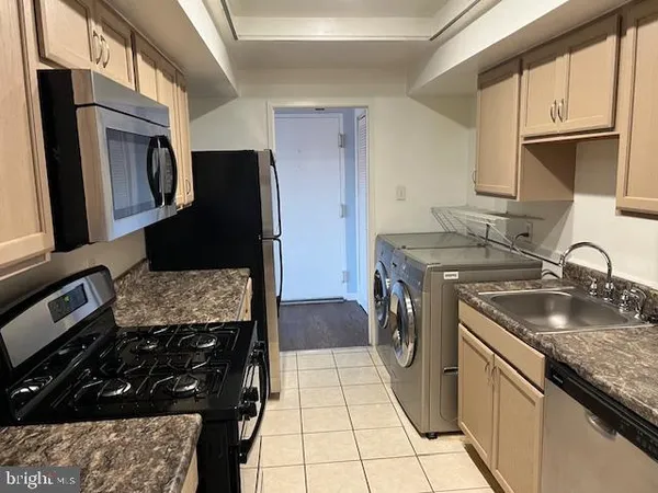 a kitchen with granite countertop a sink stove and refrigerator