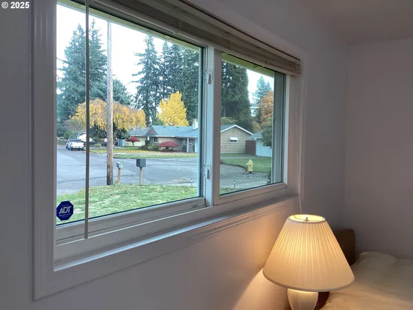 a view of a room that has a large window and front door