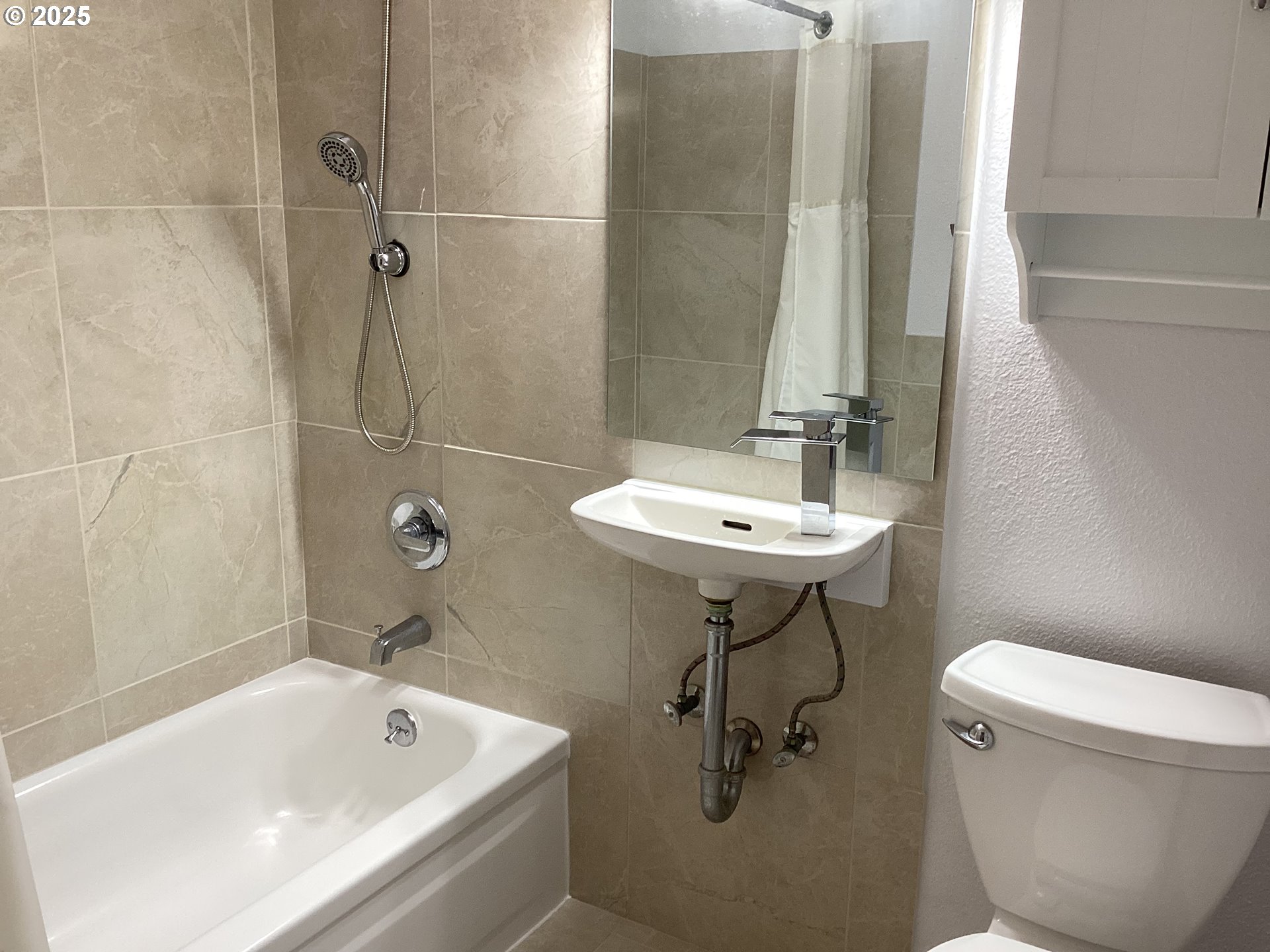17706 Southeast Washington Street Portland, OR 97233 - Photo 20 of 34 a bathroom with a sink a toilet and bathtub